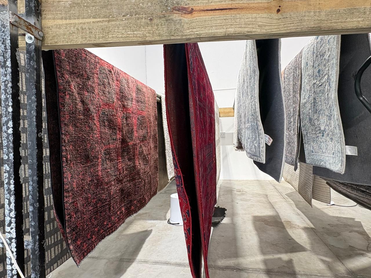 Professional rug cleaning facility with carpets and rugs hanging to dry